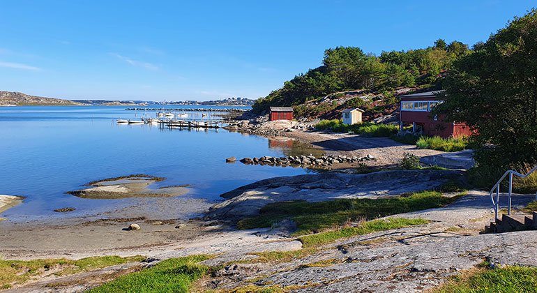 En grund havsvik med en brygga och en stenpir.